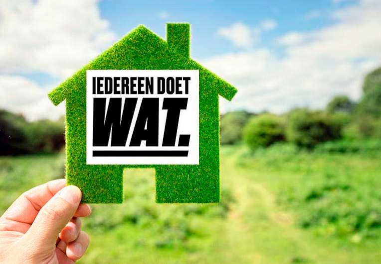 Hand die midden in een landschap een uitgeknipt groen vilten huisje omhoog houdt met de tekst: Iedereen doet WAT.
